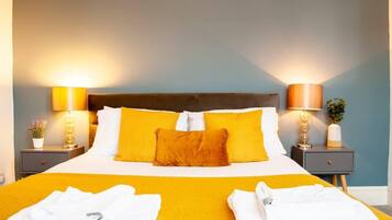 A hotel room with a large bed, two bedside tables with lamps, and a nightstand with a plant.