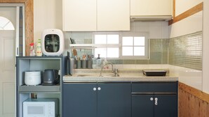 A kitchen with a built-in microwave, a coffee maker, and a sink with a faucet. - Ganghwa Sandel Bada Kids Gajok Pension (Incheon)