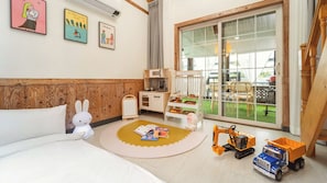 Habitació infantil amb llit, joguines i zona de jocs.