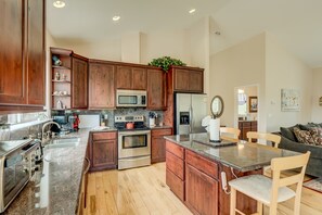 Enjoy cooking in this well-lit kitchen with a central island, sink, and stainless steel appliances.