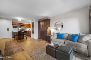 Un salon avec un canapé, un pouf et un tapis.