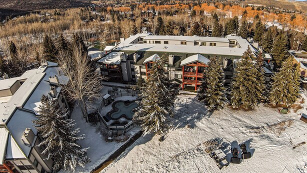 Un hôtel doté d’un grand bâtiment, d’une piscine et, au loin, d’une piste de ski.