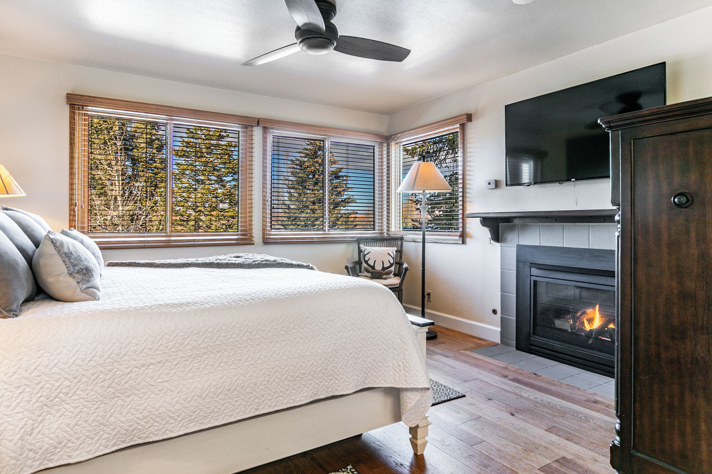 A bedroom with a bed, a fireplace, and a television.