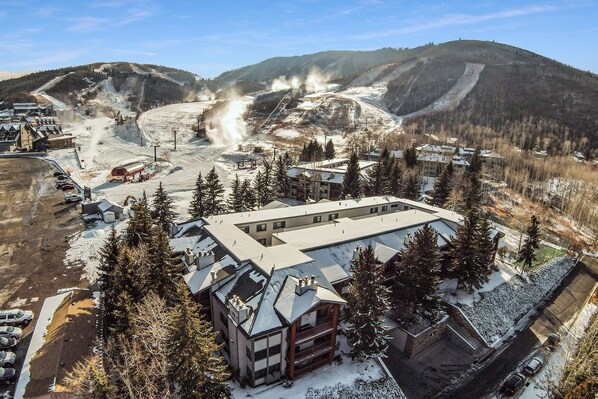 A ski resort with a large building, ski lifts, and a snowy landscape.