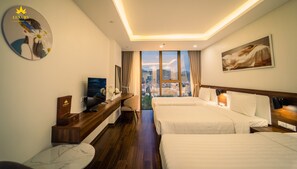 A hotel room with two beds, a TV, a desk, and a large window offering a city view.