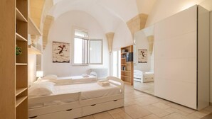 A bedroom with a large bed, a wardrobe, a TV, and a window. - Holiday Home Sleeps 6 in the Historic Center of Le (Lecce)