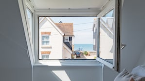Una habitación con ventana en el techo que da a la calle.