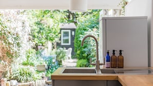 Una cocina con un lavamanos, encimera de madera y dos botellas de jabón.