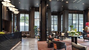A modern lobby with a marble reception desk, plush seating, large windows, and a patterned rug. - Ascott Embassy Sathorn Bangkok (Bangkok)