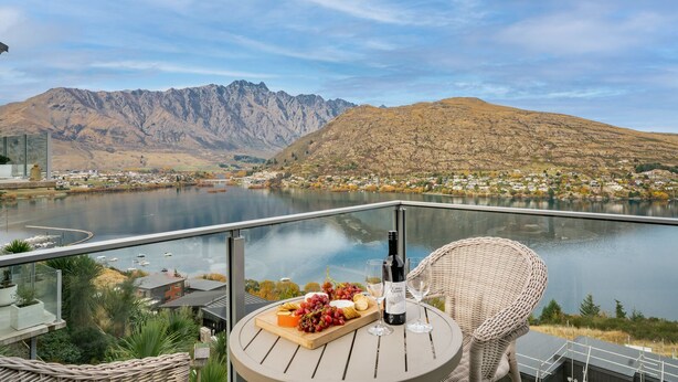 A terrace with a table set for a meal, overlooking a lake and mountains. - Lakeview Retreat - Queenstown Holiday Home (Queenstown)