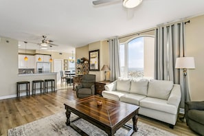 A living room with a sofa, a coffee table, and a dining area with chairs.