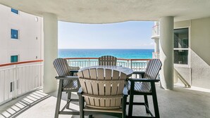 A balcony with a table and chairs, overlooking the ocean. - Beachfront With Spectacular Gulf Views-Private Balcony-Outdoor Pools-Fitness Center-Tennis Courts (Navarre)