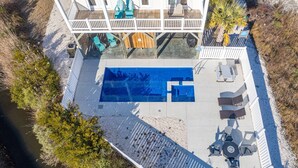 An aerial view of a pool area with a deck, lounge chairs, and a small building with a deck. - Private Saltwater Pool (Heating Optional), With Excellent Ocean Views Only 2 Blocks From the Beach (Oak Island)