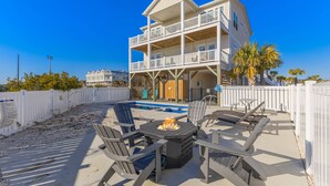 A two-story building with a balcony, a pool, and outdoor seating with a fire pit. - Private Saltwater Pool (Heating Optional), With Excellent Ocean Views Only 2 Blocks From the Beach (Oak Island)
