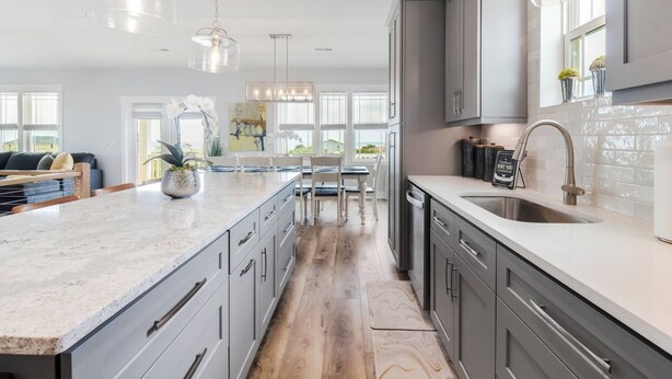A modern kitchen with a large island, grey cabinetry, and pendant lighting. - Private Saltwater Pool (Heating Optional), With Excellent Ocean Views Only 2 Blocks From the Beach (Oak Island)