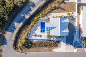 An aerial view of a modern house with a swimming pool, a covered patio, and a curved driveway. - Private Saltwater Pool (Heating Optional), With Excellent Ocean Views Only 2 Blocks From the Beach (Oak Island)