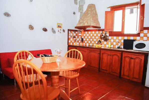 Enjoy meals at the dining table for two, surrounded by kitchen essentials and decorative accents.
