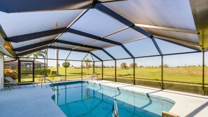 Une piscine couverte avec vue sur un terrain de golf.