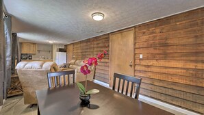 Un coin repas avec une table en bois, des chaises et une orchidée en pot.