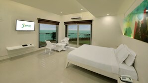Una habitación de hotel moderna con cama, televisión, escritorio y silla.