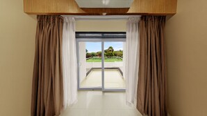 Una habitación con un ventanal corredero que da a un balcón.