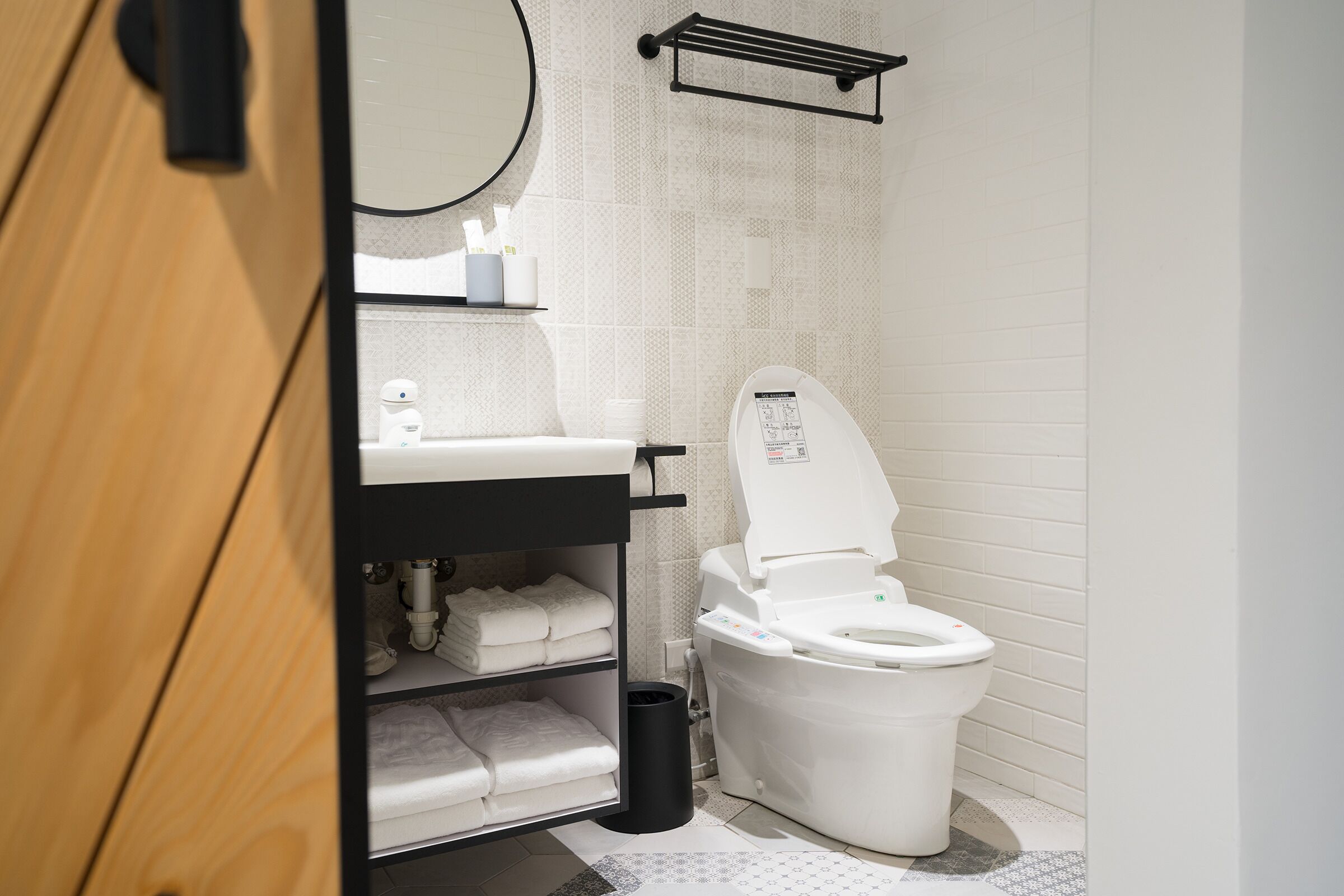 A modern bathroom with a toilet, sink, and storage shelves.