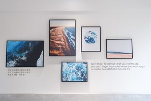 A wall with four framed pictures depicting various landscapes.