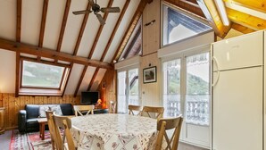 Une pièce confortable comprenant une table à manger, des chaises, un canapé, un téléviseur et un réfrigérateur.