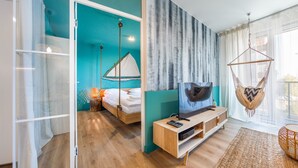 Ein modernes Schlafzimmer mit einem großen Bett, einem Fernseher und einer Hängematte.