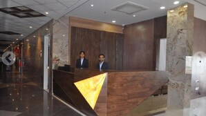 Una recepción con detalles de madera y una pared de acento en mármol.
