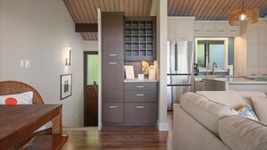 A modern kitchen with dark cabinetry, a built-in oven, and a stainless steel refrigerator. - Aloha Condos, Keauhou Resort, Condo 118, Ocean View, AC (Kailua Kona)