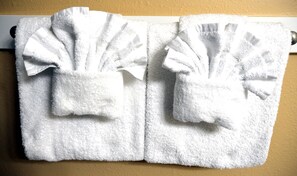 Een bad/douchecombinatie, een haardroger, handdoeken