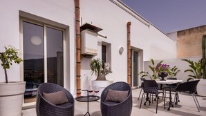 A modern outdoor patio with wicker chairs, a round table, and potted plants. - Casa dei Mori by Interhome (Terrasini)