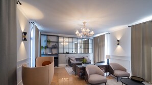 A modern living room with a sofa, armchairs, a coffee table, and a chandelier. - The Foscarini (Mogliano Veneto)