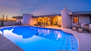 Un espace piscine avec des chaises longues et un bâtiment à l’architecture moderne.