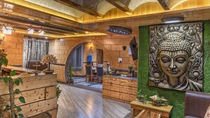 A wooden interior with a Buddha statue, wooden furniture, and a reception desk. - Kanishka Retreat Resort Chail (Kandaghat)