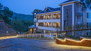 A multi-story hotel with a reception area, balconies, and a stone facade. - Kanishka Retreat Resort Chail (Kandaghat)