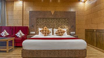 A bedroom with a large bed, wooden headboard, and a red accent wall.