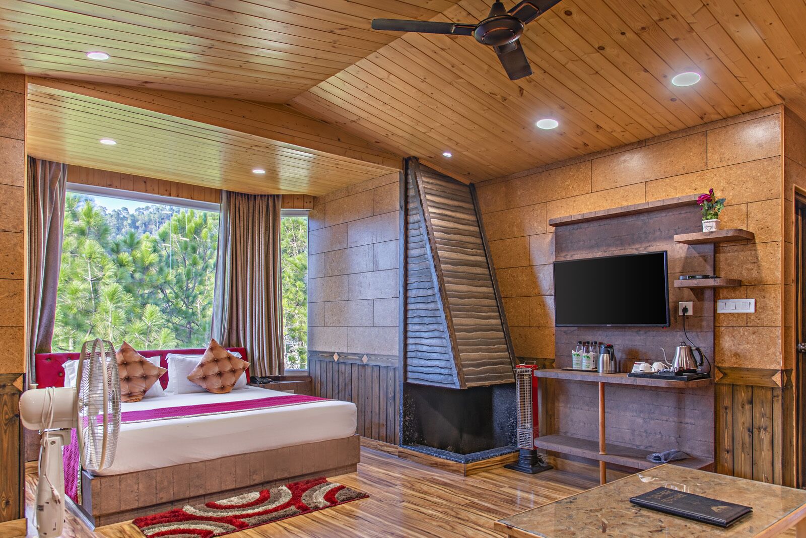 Una habitación acogedora con una cama, una chimenea, un televisor y una mesita de café.