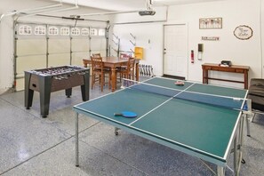 Ein Freizeitraum mit einem Kicker, einem Tischtennis-Tisch und einem Esstisch.