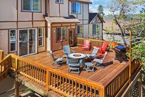 A deck with outdoor furniture, a fire pit, and a grill.