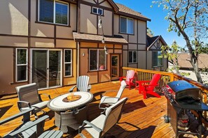 Una terraza con mobiliario exterior, una parrilla y un brasero.