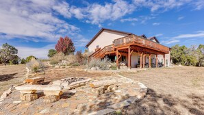 A house with a wooden deck and a stone patio. - Scenic Mancos Hideaway < 2 Mi to Mesa Verde! (Mancos)