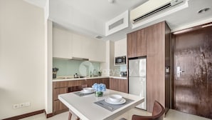 Una cocina moderna con armarios blancos, una mesa de comedor de madera y un microondas integrado.