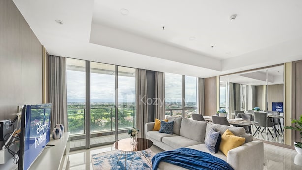 A modern living room with a large window, a flat-screen TV, a sofa, and a coffee table. - VUE by Kozystay (Curug)
