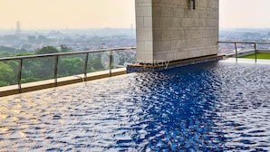 A rooftop pool with a view of a cityscape. - VUE by Kozystay (Curug)