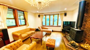 A living room with a sofa, ottoman, and a fireplace. - IPPUKAKU (Tsumagoi)