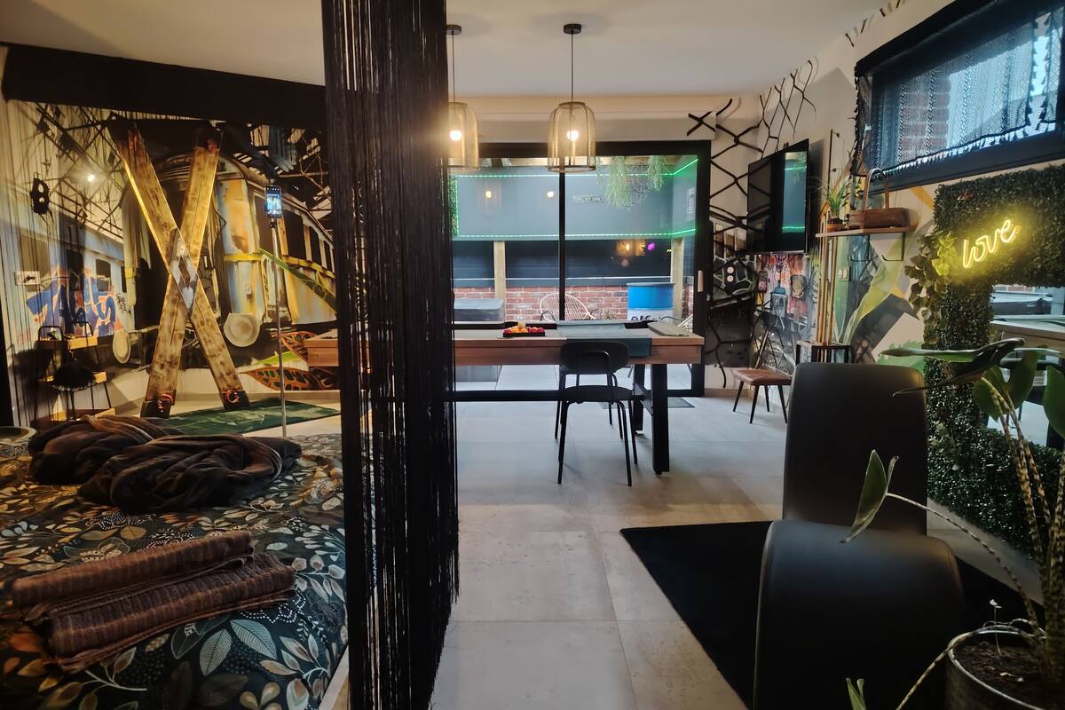 Ein modernes Wohnzimmer mit großem Fenster, einem Essbereich und einer gemütlichen Sitzecke.