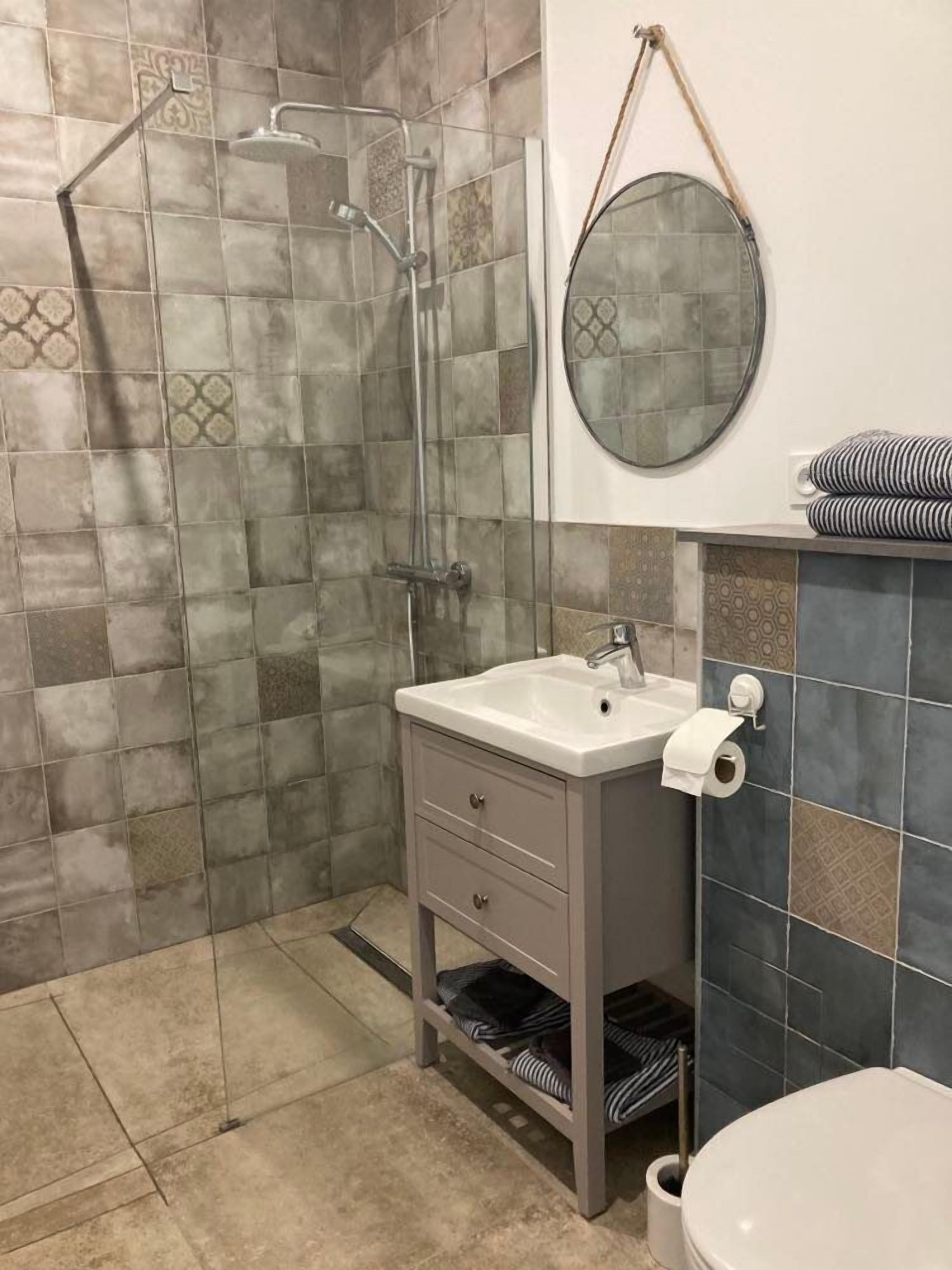 Une salle de bain avec une douche, un lavabo et des toilettes.