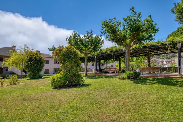 Une cour dotée d’une pergola, d’un banc et d’une petite piscine.
